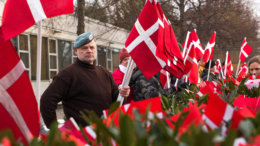 A Danish veteran holds flags bearing the names of Danish soldiers who died in Afghanistan and Iraq, in front of the U.S. embassy on the day of a march organised by veterans to protest statements by U.S. President Donald Trump about NATO soldiers in Afghanistan, in Copenhagen, Denmark, January 31, 2026. REUTERS/Tom Little