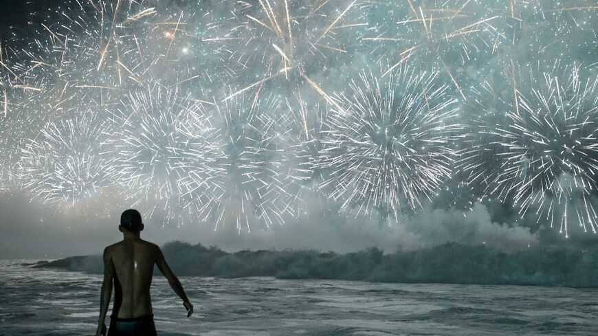 A man celebrates as he watches the traditional New Year's fireworks from the water at Copacabana Beach in Rio de Janeiro, Brazil, on January 1, 2026