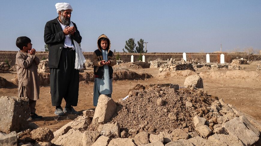 Gul Ahmad (centre) along with his deceased stepbrother Habibullah's son Waheed (right) and Saeed offering prayers over his grave in Ghunjan