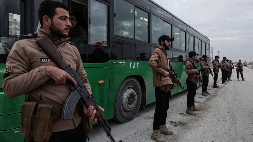 Syrian government forces supervise the evacuation of Aleppo's Kurdish-majority Sheikh Maqsud neighbourhood