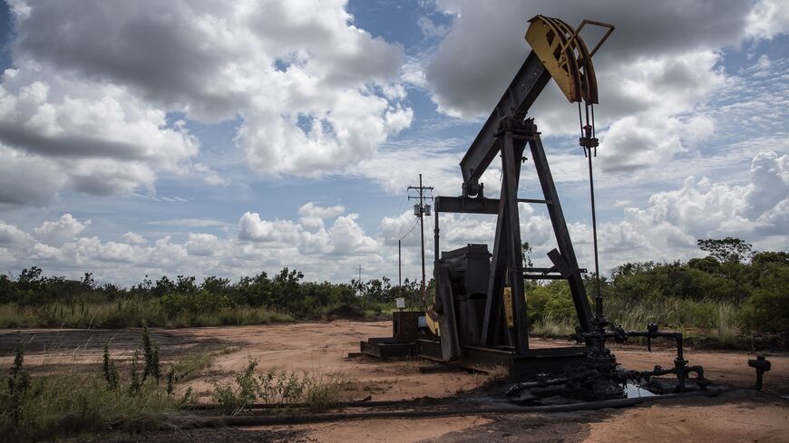 A pump jack stands near an oil spill at a facility in Venezuela.