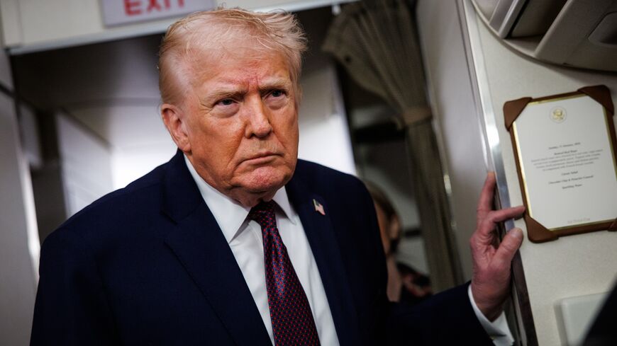 US President Donald Trump takes questions from the members of the press aboard Air Force One on Jan. 11, 2026, en route back to the White House from Palm Beach, Florida. 