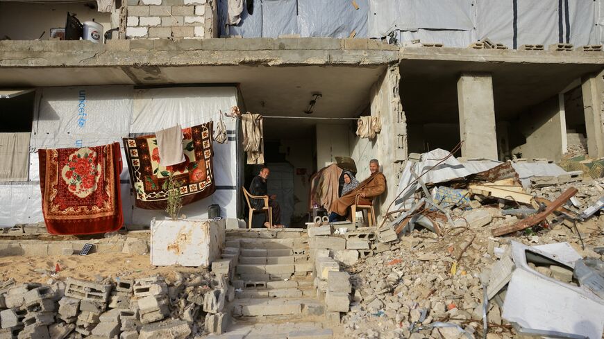 Palestinians sit amid destroyed buildings by the Israeli military in Khan Younis in the southern Gaza Strip on Jan. 27, 2026. 