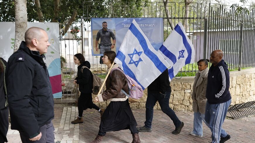 Mourners carrying Israeli flags gathered for the funeral ceremony in Meitar