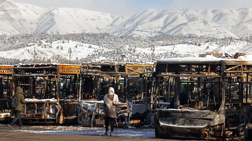 At a bus depot in the capital, roughly a dozen buses burnt in recent protests were lined up in the parking lot