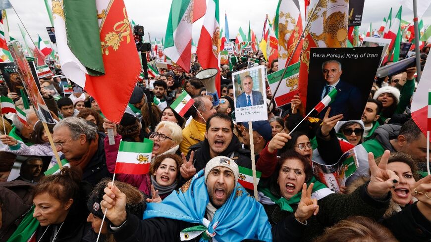 Iranian demonstrators hold flags and posters depicting Iran's former crown prince and now key opposition figure Reza Pahlavi in Munich