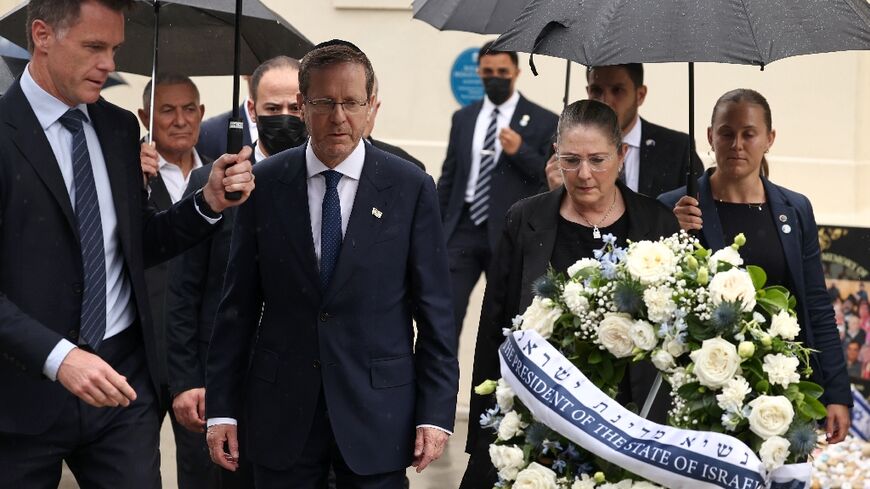 Israelli President Isaac Herzog (C) and his wife Michal (2nd R) are escorted by New South Wales Premier Chris Minns (L) as they lay a wreath for the victims of the December 14, 2025 gun attack at the Bondi Pavilion, in Sydney on February 9, 2026