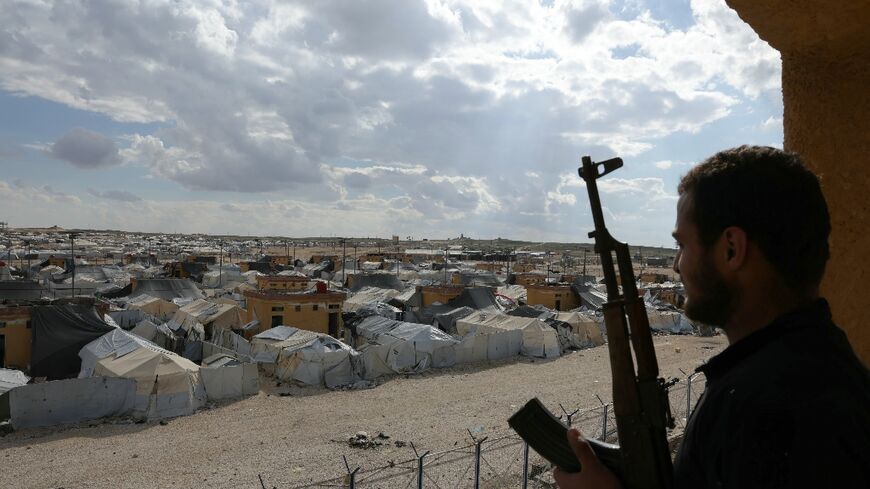 A Syrian troop looks out over the Al-Hol camp, where thousands of family members of suspected IS jihadists left last month