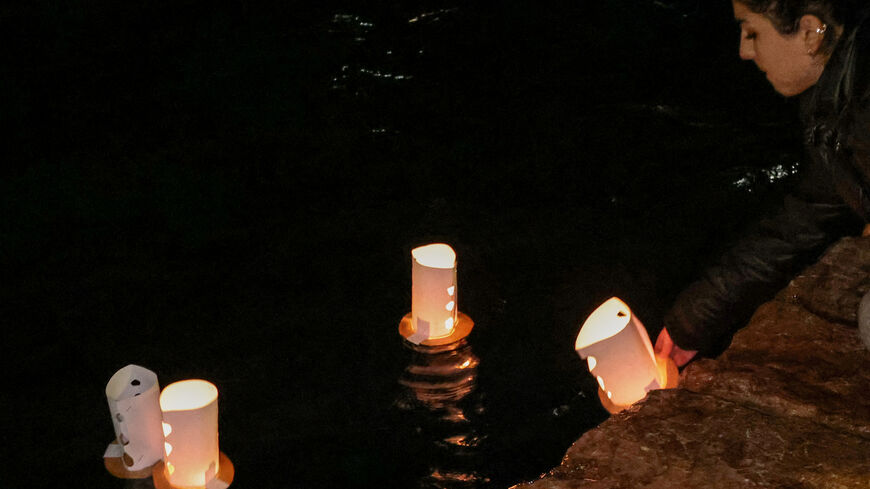 FILE PHOTO: A protester releases candles into the sea in memory of the dead migrants, during a protest following a migrant boat collision with the coast guard, in Chios, Greece, February 4, 2026. REUTERS/Konstantinos Anagnostou/File Photo