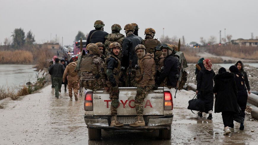 FILE PHOTO: Military personnel in a vehicle at the crossing connecting the two banks of the Euphrates River, as they attempt to cross to the other side after the Syrian Democratic Forces (SDF) withdrew from Deir al-Zor province and the Syrian army took full control over the area, in Deir al-Zor, Syria, January 18, 2026. REUTERS/Khalil Ashawi/File Photo