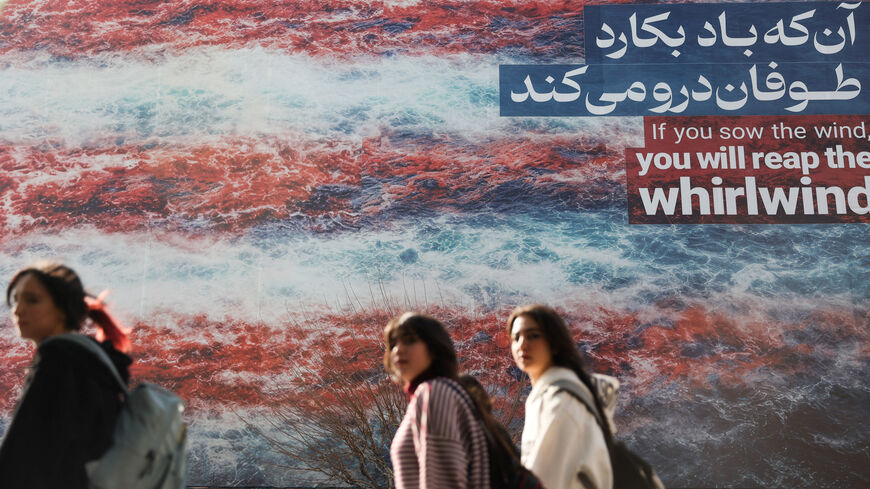 Iranian women walk past an anti-U.S. billboard in Tehran, Iran, February 19, 2026. Majid Asgaripour/WANA (West Asia News Agency) via REUTERS