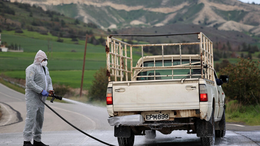 Man in a hazmat suit disinfects a vehicle and the road leading to farming units Oroklini, Cyprus, following cases of foot and mouth disease among livestock, Cyprus February 24, 2026. REUTERS/Yiannis Kourtoglou