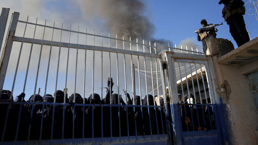 FILE PHOTO: Members of the Syrian government security forces stand guard as a group of female detainees gather at al-Hol camp after the government took control of it following the withdrawal of Syrian Democratic Forces (SDF), in Hasaka, Syria, January 21, 2026. REUTERS/Khalil Ashawi/File Photo