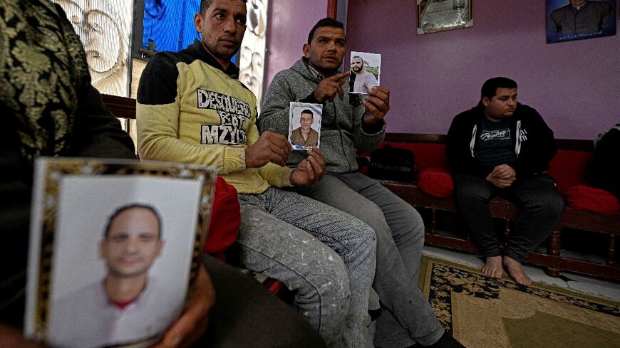 Relatives holding portraits of those believed to to have gone missing while making the journey to Europe through Libya