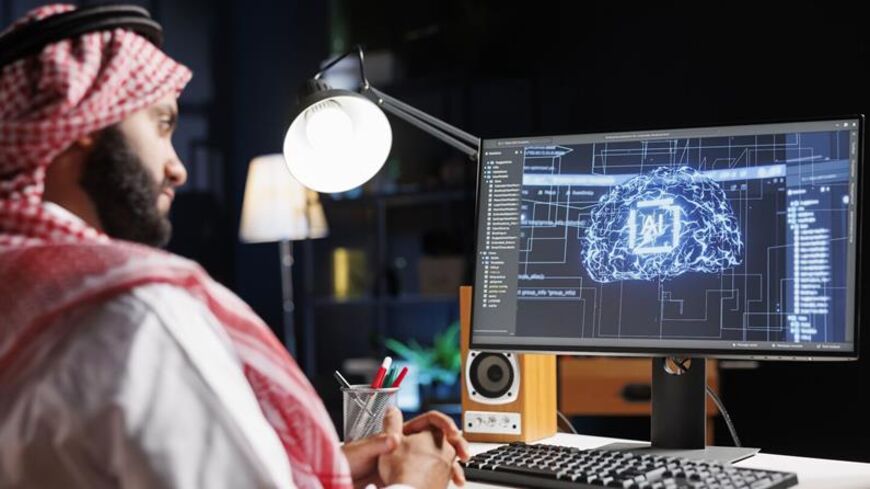 Detailed image of Middle Eastern developer in front of desktop pc monitoring a complex network, ensuring data security and efficient computing using cloud, AI and machine learning. — Getty Images