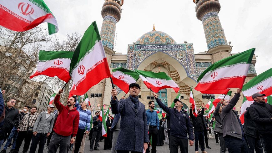 Some pro-goverbment protestors waved national flags during a demonstration in support of the government, but US and Israeli strikes and a striong security presence drove many Iranians to seek shelter
