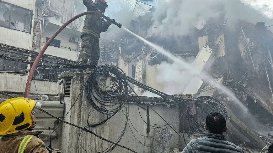 Firefighters at a site  of an Israeli air strike in Beirut’s southern suburbs