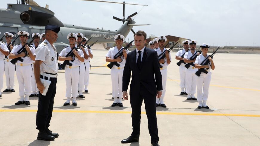 French president Emmanuel Macron (C) reviews the troops as he visits the French military base in Djibouti in 2019
