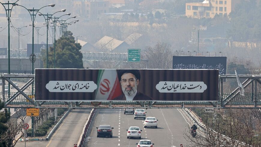 Motorists drive past a billboard of Iran's new supreme leader Ayatollah Mojtaba Khamenei in Tehran on March 14, 2026