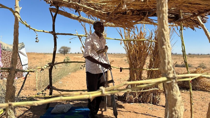 Ibrahim Noureldin leans on crutches at a makeshift shelter in the town of Tawila, Sudan 