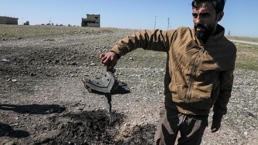 A man shows the remains of a drone at the airport in Iraq's Erbil 