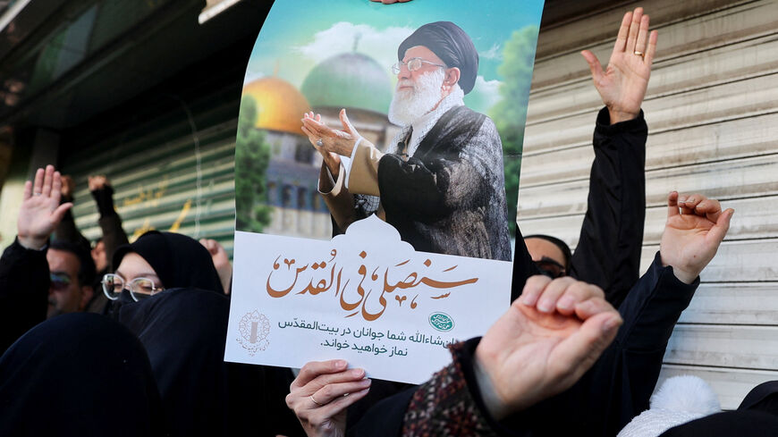 A woman holds a poster with the picture of Iran's Supreme Leader Ayatollah Ali Khamenei as people gather after Khamenei was killed in Israeli and U.S. strikes on Saturday, in Tehran, Iran, March 1, 2026. Majid Asgaripour/WANA (West Asia News Agency) via REUTERS