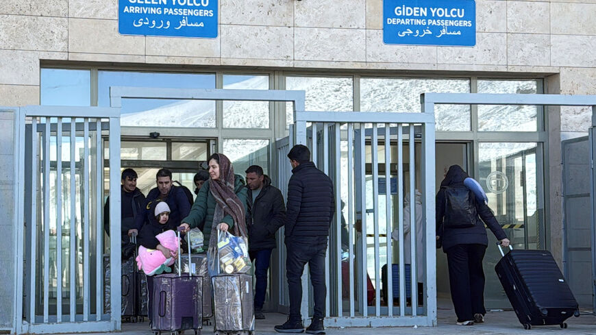 People exit and enter at the Kapikoy border crossing between Turkey and Iran, in Van province, Turkey, March 1, 2026. REUTERS/Ismet Mikailogullari