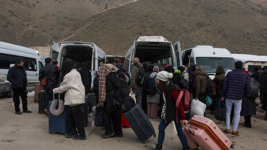 People wait for transportation to the city center after crossing from Iran into Turkey at the Kapikoy Border Gate in eastern Van province, Turkey, March 2, 2026. REUTERS/Dilara Senkaya