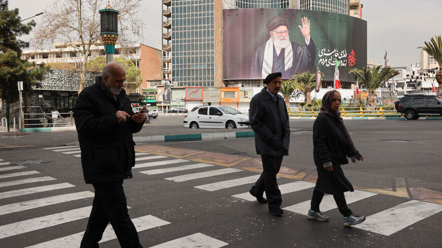 People walk near a billboard of Iran's late Supreme Leader Ayatollah Ali Khamenei on a street, after he was killed in Israeli and U.S. strikes on Saturday, in Tehran, Iran, March 2, 2026. Majid Asgaripour/WANA (West Asia News Agency) via REUTERS