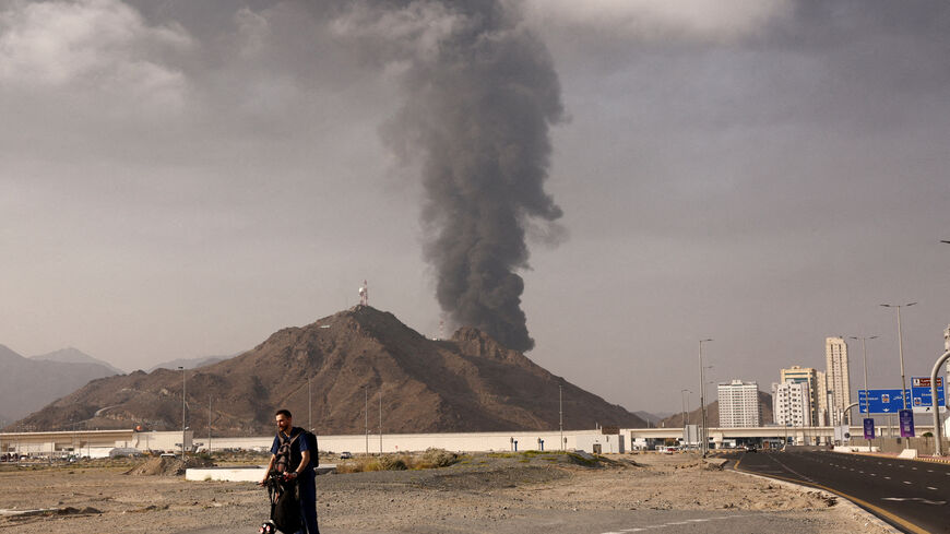 FILE PHOTO: A person rides on a scooter as smoke rises in the Fujairah oil industry zone following a fire caused by debris after interception of a drone by air defenses, in Fujairah, United Arab Emirates, March 3, 2026. REUTERS/Amr Alfiky/File Photo