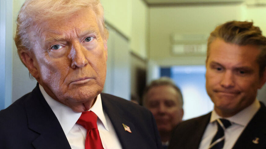 U.S. President Donald Trump, with Secretary of Defense Pete Hegseth at his side, looks on as he speaks to reporters aboard Air Force One on a flight from Dover, Delaware, to Miami, Florida, U.S., March 7, 2026. REUTERS/Kevin Lamarque