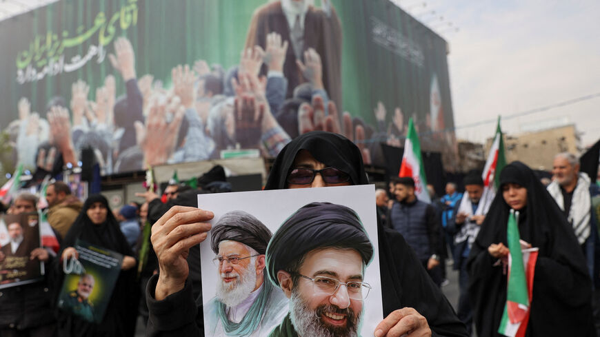 A woman holds an image of Iran's new supreme leader, Mojtaba Khamenei, alongside late Iranian Supreme Leader Ayatollah Ali Khamenei, during a funeral ceremony for the Iranian military commanders who were killed in strikes, amid the U.S.-Israeli conflict with Iran, in Tehran, Iran, March 11, 2026. Majid Asgaripour/WANA (West Asia News Agency) via REUTERS