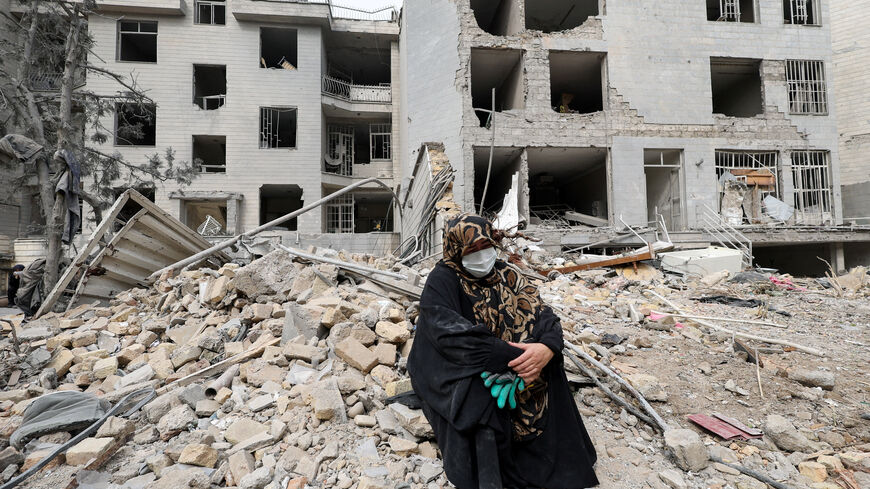 A woman sits outside her destroyed apartment after it was damaged by an airstrike while she was inside, amid the U.S.-Israeli conflict with Iran, in Tehran, Iran, March 12, 2026. REUTERS/Alaa Al Marjani