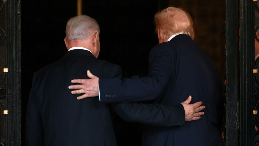 U.S. President Donald Trump and Israeli Prime Minister Benjamin Netanyahu embrace as they walk into Trump's Mar-a-Lago club in Palm Beach, Florida, U.S., December 29, 2025. REUTERS/Jonathan Ernst/File Photo