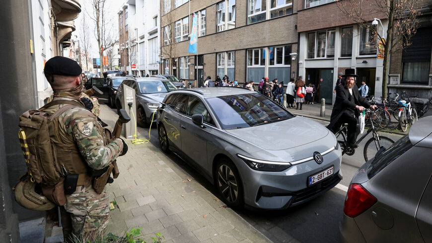 A Jewish man rides past Belgian army personnel patrolling a street as part of a deployment of soldiers outside Jewish institutions in Antwerp and Brussels following attacks at Jewish sites in Belgium and other European countries, in Antwerp, Belgium, March 23, 2026. REUTERS/Yves Herman