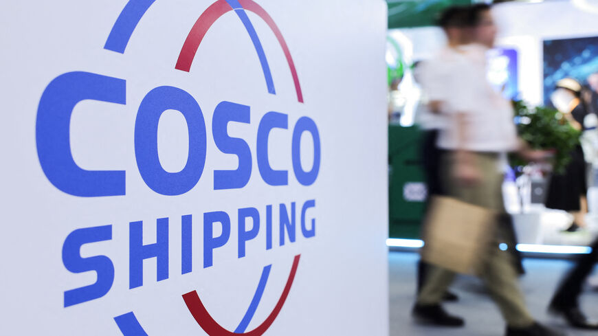 FILE PHOTO: People walk next to a logo of China Ocean Shipping Company (COSCO) at the China International Fair for Trade in Services (CIFTIS) in Beijing, China, September 11, 2025. REUTERS/Maxim Shemetov/File Photo