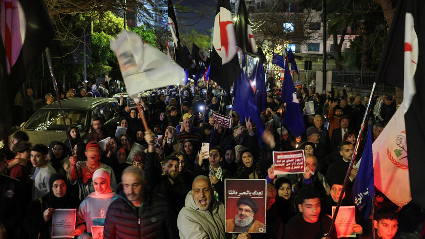 A person raises a portrait of late Hezbollah leader Hassan Nasrallah during a demonstration in support of Hezbollah and Iran, amid escalating hostilities between Israel and Hezbollah, as the U.S.-Israeli conflict with Iran continues, in Beirut, Lebanon, March 27, 2026. REUTERS/Amr Abdallah Dalsh
