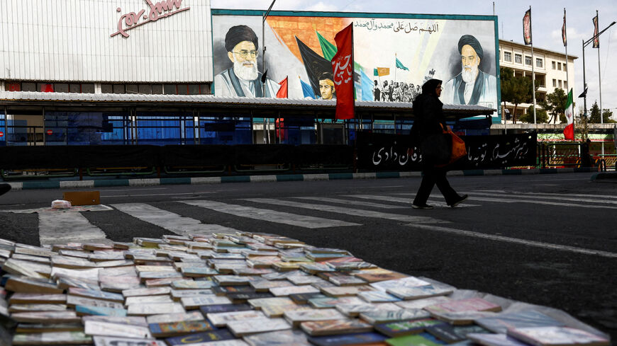 FILE PHOTO: A woman walks next to a mural depicting the late leader of the Islamic Revolution, Ayatollah Ruhollah Khomeini, and the late Supreme Leader of Iran, Ayatollah Ali Khamenei, amid the U.S.-Israeli conflict with Iran, in Tehran, Iran, March 22, 2026. Majid Asgaripour/WANA (West Asia News Agency) via REUTERS/File Photo