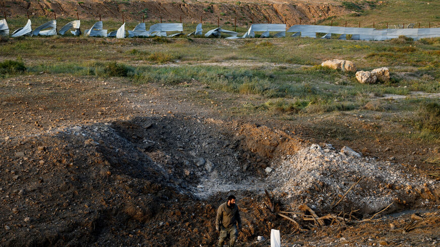 A man stands at an impact site following an Iranian missile strike, as the U.S.-Israeli conflict with Iran continues, in southern Israel, March 29, 2026. REUTERS/Amir Cohen