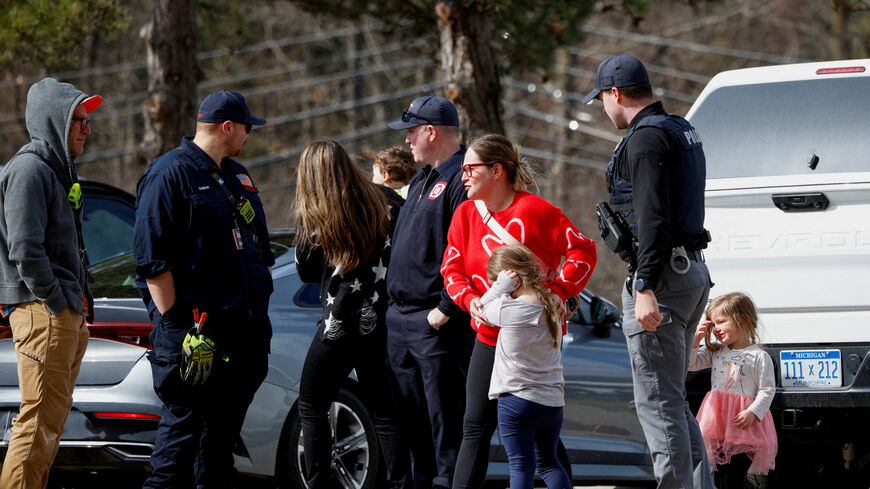 FILE PHOTO: Parents who pulled out their kids from the Temple Israel Synagogue stand near police after the Michigan State Police reported an active shooting incident there, in West Bloomfield, Michigan, U.S., March 12, 2026. REUTERS/Rebecca Cook/File Photo