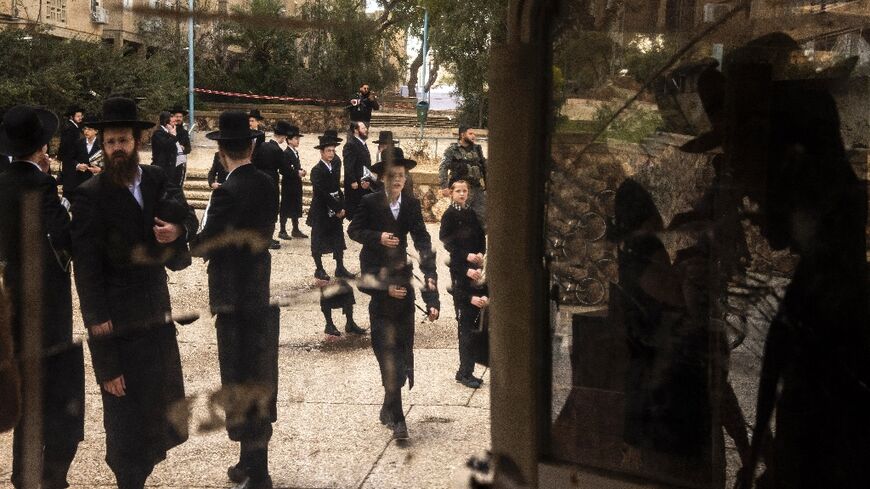 Israeli Orthodox Jews inspect the site of an Iranian missile strike in Arad on March 22