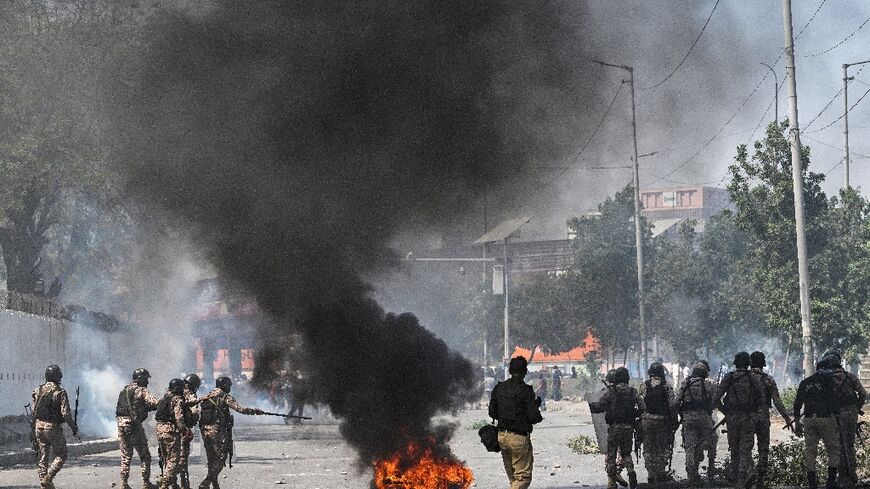 Security personnel fire tear gas as Shiite Muslims shout slogans during a protest outside the US consulate in Karachi after the death of Iran's supreme leader Ayatollah Ali Khamenei amid US-Israel strikes