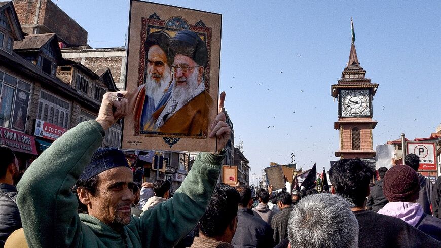 A Shiite Muslim holds a photograph of Iran supreme leader Ayatollah Ali Khamenei (R) and former leader Ayatollah Ruhollah Khomeini during an anti-US and Israel protest in Srinagar on March 1, 2026