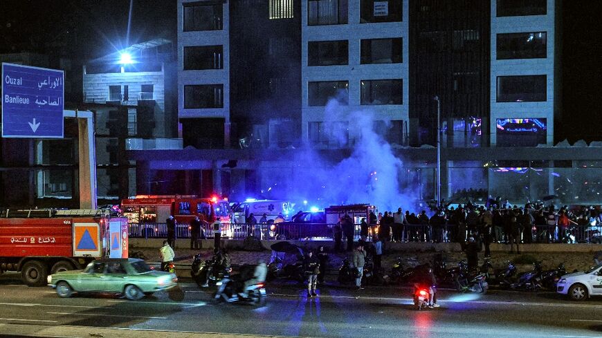 Rescuers rush to the site of an Israeli strike on a vehicle along the highway leading to Beirut's international airport