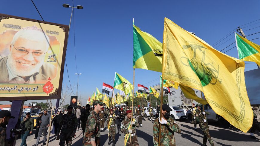 Fighters lift flags of Iraq and paramilitary groups, including al-Nujaba and Kataib Hezbollah, during a funeral in Baghdad for five militants killed a day earlier in a US strike in northern Iraq, on Dec. 4, 2023.