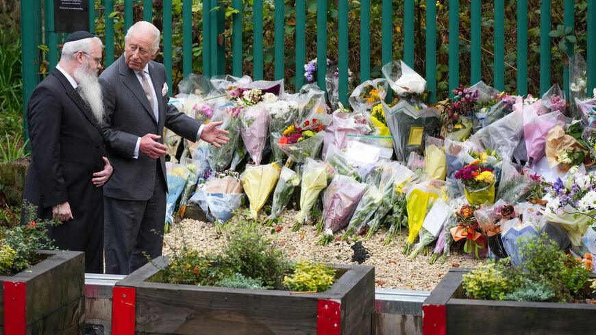 Rabbi Daniel Walker and King Charles III view floral tributes during a visit to Heaton Park Hebrew Congregation Synagogue on Oct. 20, 2025, in Manchester, England. 