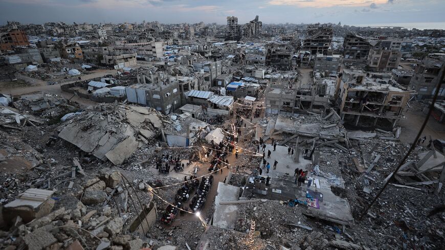 Displaced Palestinians gather for a fast-breaking Iftar meal amid the rubble of destroyed buildings at the Jabalia refugee camp, in the northern Gaza Strip, during the Muslim holy fasting month of Ramadan, Feb. 23, 2026.