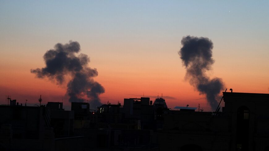 Black plumes of smoke ascend from the site of airstrikes on Friday in a central area of the Iranian capital Tehran