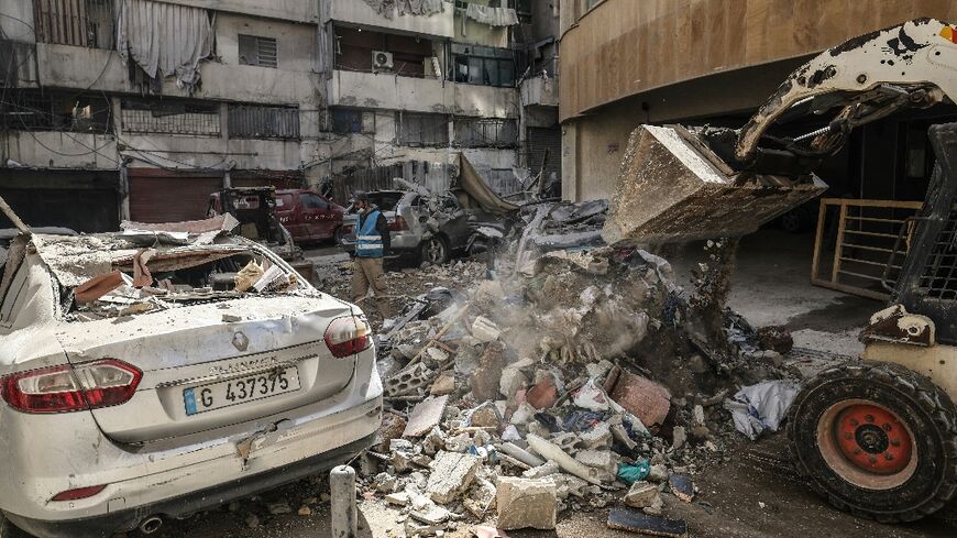 Workers clear debris from a street after an Israeli strike in central Beirut'