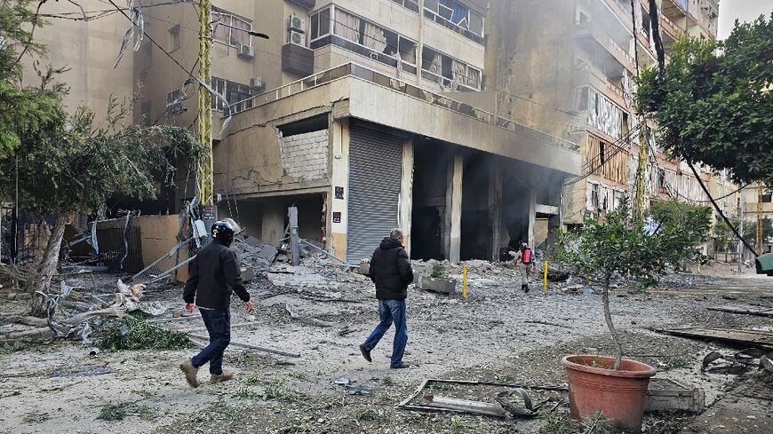Firefighters inspect the site of an overnight Israeli airstrike on the Haret Hreik neighbourhood in Beirut's southern suburbs
